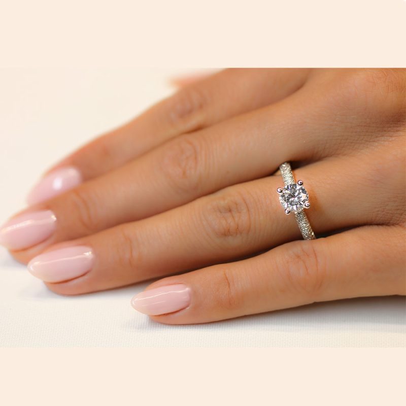 בחורה עונדת טבעת אירוסין יהלום סוליטר עם חישוק טבעת משובץ יהלומים