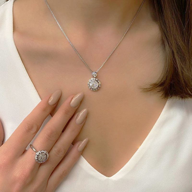 בחורה עונדת סט תכשיטים תליון וטבעת באותו עיצוב יהלומים בזהב לבן