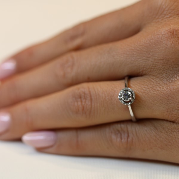 טבעת אירוסין עם יהלום עגול מוקף בהילה של יהלומים בזהב לבן