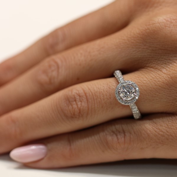 טבעת אירוסין יהלום מרכזי מוקף בהילה-שורה של יהלומים סביבו חישוק טבעת משובץ יהלומים בזהב לבן